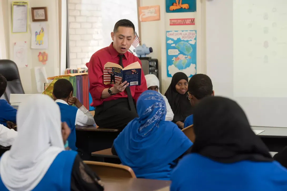 Student teacher reading to students in classroom